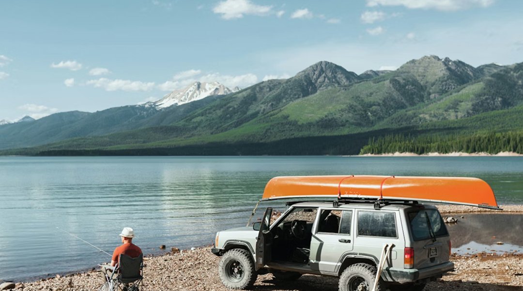 a man fishing by the lake with a RV